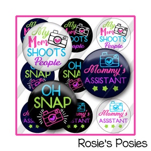 May include: A set of 10 round buttons with various designs and text related to photography. The buttons feature a camera icon, the text "My Mom Shoots People", "Oh Snap", and "Mommy's Assistant".