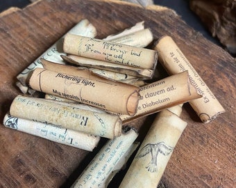 May include: A pile of rolled up parchment paper scrolls with handwritten text, including the phrases "flickering light, My wealth increases", "To find true love", "If brever bind from now until the end of time", and "Ex spiritiba him sie te aeris. Qui Ompotentiam".