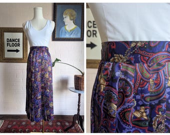 May include: A long, pleated skirt with a paisley pattern in shades of purple, blue, red, and gold. The skirt is paired with a white tank top on a mannequin. The image also includes a framed sign that says "DANCE FLOOR".