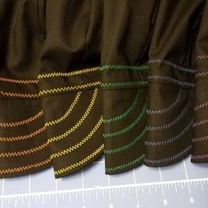 May include: Six black fabric hats with different colored stitching around the brim. The stitching is in a zig-zag pattern and creates a rainbow effect.