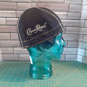 May include: Black beanie with a gold embroidered "Crown Royal" logo. The beanie is on a blue mannequin head.