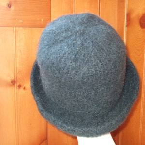 May include: A dark green fuzzy wool hat with a wide brim.