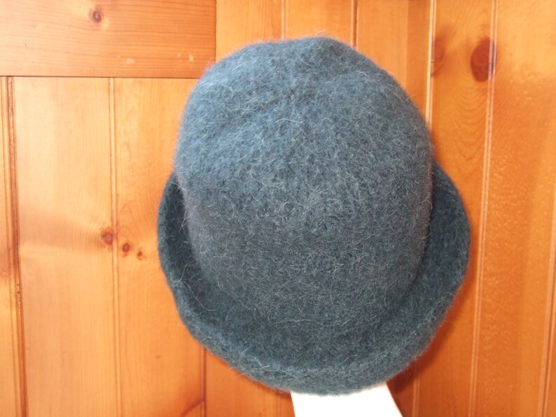 May include: A dark green fuzzy wool hat with a wide brim.