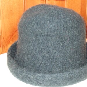 May include: A dark blue, fuzzy, round hat with a wide brim.