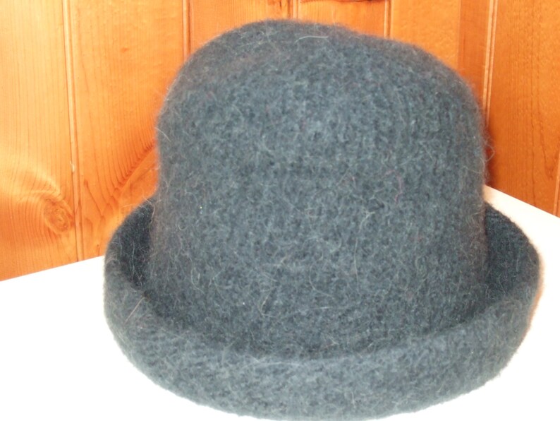 May include: A dark blue, fuzzy, round hat with a wide brim.