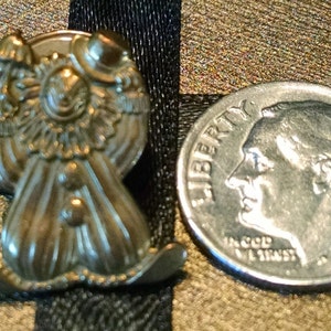 May include: Gold-toned metal pin featuring a clown with a large smile, wearing a hat and holding a balloon. The pin is about the size of a dime.