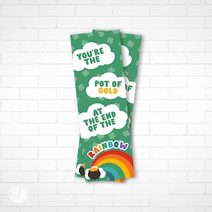 Könnte beinhalten: Zwei Lesezeichen zum Thema St. Patrick's Day mit grünem Hintergrund und weißen Wolken. Der Text auf den Lesezeichen lautet "You're the Pot of Gold at the End of the Rainbow." Ein Regenbogen und ein Goldtopf befinden sich unten.