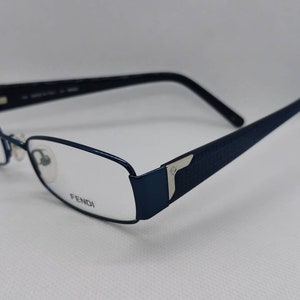 May include: Blue rectangular eyeglasses with a silver Fendi logo on the side.