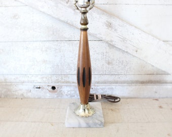 May include: A mid-century modern table lamp with a wooden base and a marble base. The wooden base has black accents.