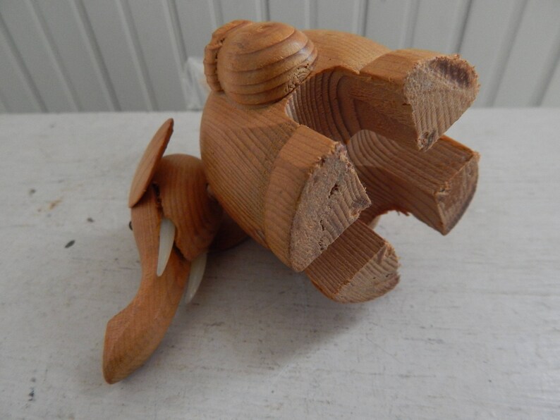 Puede incluir: Un elefante de juguete de madera de color marr&oacute;n claro. El elefante est&aacute; hecho de varias piezas de madera y tiene una superficie texturizada. El elefante est&aacute; de pie sobre sus patas traseras con sus patas delanteras levantadas en el aire.