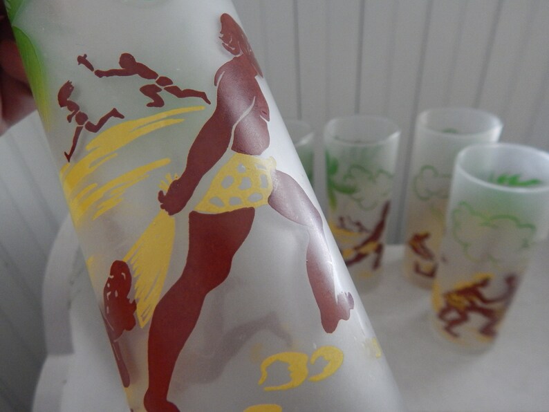 K&ouml;nnte beinhalten: Satz von sechs gefrosteten Gl&auml;sern mit Vintage-Design. Die Gl&auml;ser zeigen eine braune Silhouette einer Person in einem gelben Badeanzug, umgeben von gelben und wei&szlig;en abstrakten Formen.