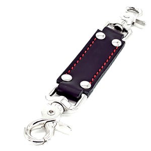 May include: Black leather strap with red stitching and two silver swivel clips.