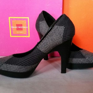 May include: Black and gray plaid high-heeled pumps with a black platform. The shoes have a pointed toe and a thin heel. The brand name "ISAAC MIZRAHI for TARGET" is printed on a white square label.