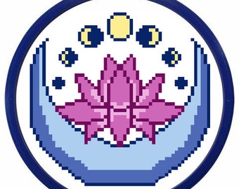 May include: A blue and purple embroidery hoop with a design of a pink lotus flower inside a crescent moon with yellow and black moons above the flower.