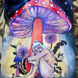 May include: A watercolor painting of a woman sitting under a large, purple and red mushroom with white spots. The woman is nude and has long white hair. The background is a dark blue with stars and a yellow glow.