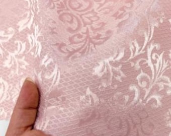 May include: Pink fabric with a white damask pattern. The fabric has a subtle sheen and a soft texture.