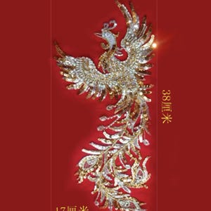 May include: A decorative phoenix applique with gold and silver sequins on a red background. The phoenix is 15 inches tall and 6.7 inches wide. The image includes the text "38 cm" and "17 cm".