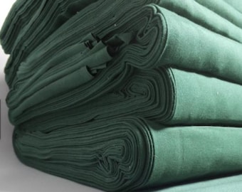 May include: A stack of rolled green fabric, tightly wound and layered. The fabric appears to be a solid color, with a soft texture. The rolls are neatly stacked, showing the edges of the fabric.