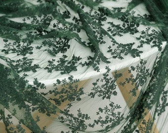 May include: Green floral lace fabric with a delicate pattern. The lace is sheer and has a soft, flowing texture.