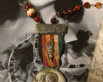 NEVER LET GO Munich Germany torch medal upscaled repurposed beaded vintage assemblage necklace altered art mixed media