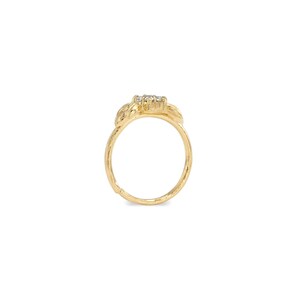 A gold ring with a floral design and a small gemstone in the center.