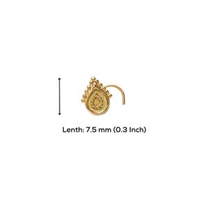 A gold-colored nose stud with a decorative design on it.