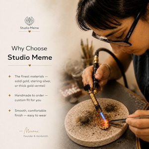 a person working on a piece of jewelry, using a torch to shape and manipulate the material. The person is wearing glasses and appears to be focused on their work.