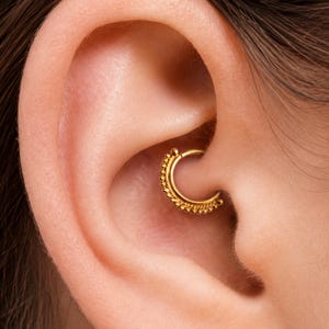 A gold-colored earring is visible in the person's ear.