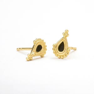 a pair of gold earrings with black gemstone accents, placed side by side on a white background.