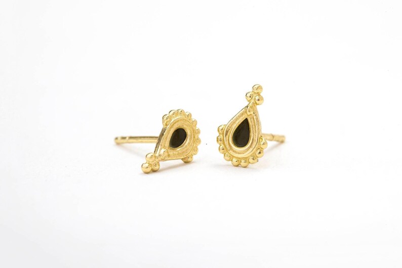 a pair of gold earrings with black gemstone accents, placed side by side on a white background.