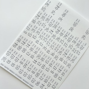 May include: A sheet of white planner stickers featuring black text for the year 2027. The stickers list weekly date ranges with Monday starts, week numbers from W01 to W52, and month abbreviations. The text 2027 DATED WEEKLY STICKERS | MONDAY START and SMCO are printed on the sheet.