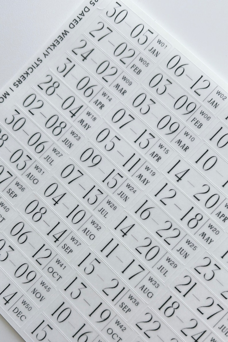 May include: A sheet of clear adhesive stickers featuring black printed text for a dated weekly planner. Each sticker displays a specific week range, such as 30-05 JAN, along with the corresponding week number, like W01, in a serif font style.