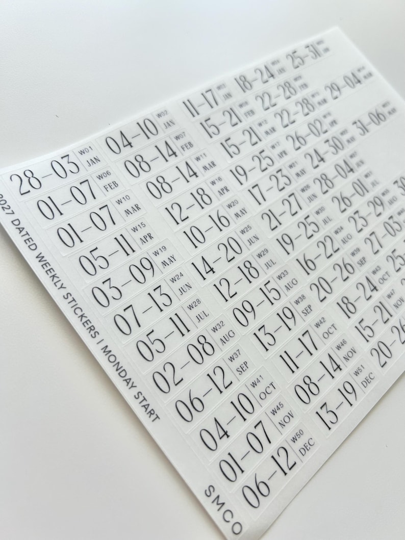 May include: A sheet of clear adhesive stickers featuring black text for 2027 dated weekly planners with a Monday start. The stickers display numerical date ranges for each week of the year, organized by month, with week numbers and month abbreviations.