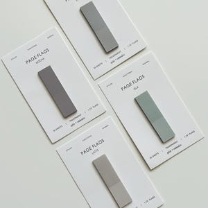 May include: Four packs of rectangular page flags in various colors: stone, mocha, isla, and latte. Each pack has a rectangular flag with the text "PAGE FLAGS" and "50 SHEETS". The flags are 1.75 inches long and transparent.