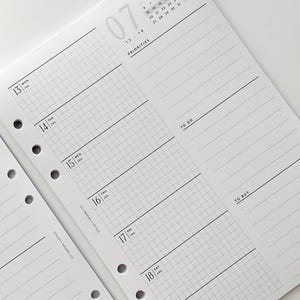 May include: A close-up of a white planner insert with a July calendar and grid-lined sections for each day of the week. The planner pages have pre-punched holes for binding and include sections for priorities, to-do lists, and to-buy lists.