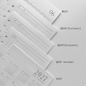 May include: A set of white paper planner inserts with black text, featuring monthly and yearly calendar layouts for 2027. The pages include punched holes on the left side and are labeled with codes M01P, Q04P, Y01P, and YRLY QRTLY M01P BUNDLE.