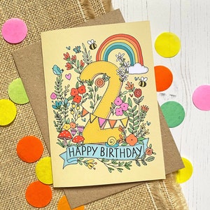 Pode incluir: Um cart&atilde;o de anivers&aacute;rio amarelo com um grande n&uacute;mero "2" rodeado de flores, um arco-&iacute;ris e o texto "Feliz anivers&aacute;rio".