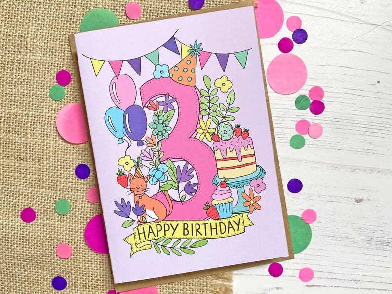 May include: A birthday card with a pink number 3, decorated with flowers, balloons, and a cake. An orange cat sits near the bottom, and the words "HAPPY BIRTHDAY" are written on a banner. Colorful confetti surrounds the card.