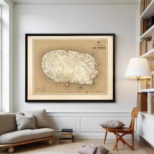 May include: A framed vintage map of Ilha Terceira, Azores, with a beige background and black frame. The map features detailed cartography with red markings and text. The artwork is displayed in a living room setting with a sofa, chair, and bookshelf.