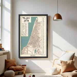 Puede incluir: Mapa vintage enmarcado de Tel Aviv y Jaffa, Israel, en un marco negro. El mapa presenta diseños de calles detallados, con texto en la esquina superior izquierda. El mapa está sobre un fondo azul claro y beige.