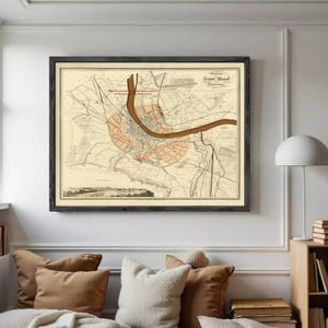 Peut inclure: Carte ancienne encadrée de Bâle, Suisse, avec un plan détaillé de la ville et une rivière. Le cadre noir entoure la carte sur fond beige avec des détails rouges et bruns. Le texte sur la carte est en allemand.