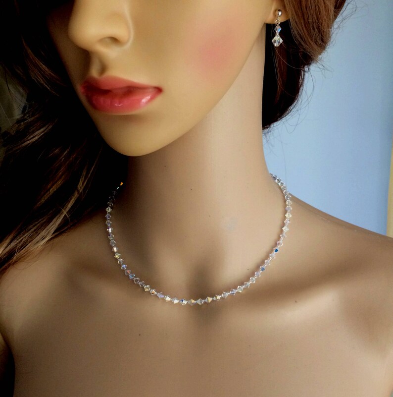 May include: A delicate crystal necklace with a simple design. The necklace is made of small, clear crystals that are strung together on a silver chain. The necklace is perfect for adding a touch of sparkle to any outfit.