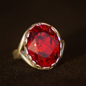 Peut inclure: Une bague en argent avec une grosse pierre précieuse rouge facetée.