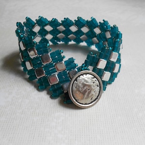 May include: A teal and silver beaded bracelet with a silver button clasp.