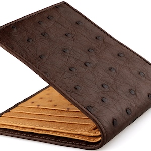 May include: A brown leather wallet with a tan leather interior. The wallet has a textured ostrich pattern.