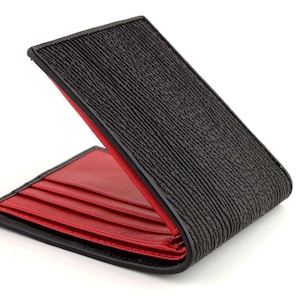 May include: A black leather wallet with a red interior. The wallet is folded open, showing the multiple card slots.