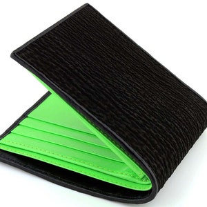 May include: A black leather wallet with a green interior. The wallet is folded in half and the green interior is visible.