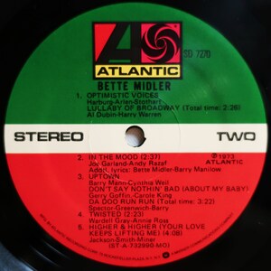 May include: A red, white and black vinyl record with a green label. The label features the Atlantic Records logo and the text "Bette Midler" in white. The record is titled "Two" and includes a list of songs with their titles, artists and lengths.