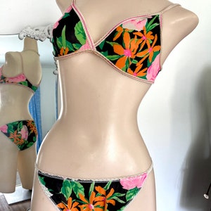 Vintage 1970s Black Floral Nylon String Bikini and Bra Set With An Orange Green and Bright Pink Botanical Print Size Small