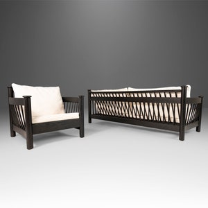 May include: A black wooden sofa and armchair with white cushions. The sofa and chair have a unique woven design on the back.